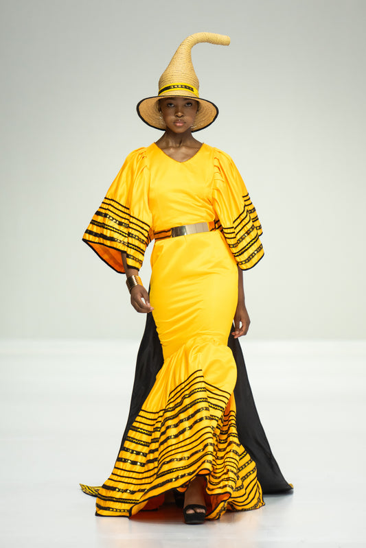 Gold full length Mzamba dress worn with a black train